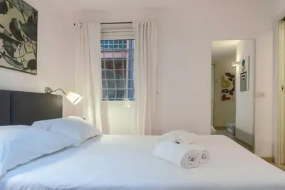 a white bed with two rolled towels on it at My Cosy Home in Rome