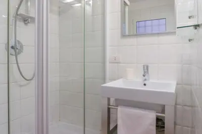 a white bathroom with a sink and a shower at My Cosy Home in Rome