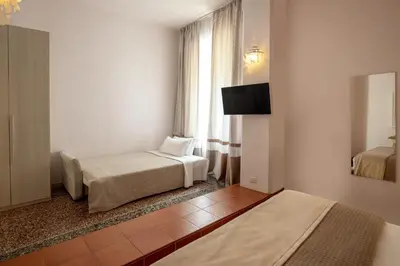 a hotel room with two beds and a window at Baldassini Suites in Rome