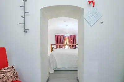 a bedroom with a white bed and a red curtain at Diana Romantic Loft in Rome