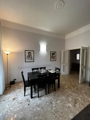 a dining room with a black table and chairs at Vatican Attic in Rome