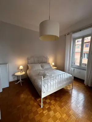 a bedroom with a bed and two tables and a lamp at Vatican Attic in Rome