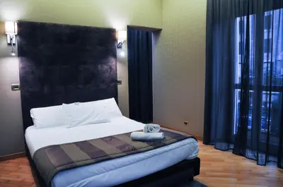 a bedroom with a bed with a black headboard at Hotel Regina Margherita in Rome