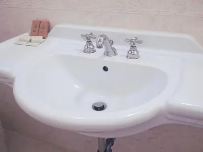 a white bathroom sink with two faucets on it at Hotel Regina Margherita in Rome