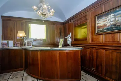 a bar in a room with wooden walls and a chandelier at Hotel Regina Margherita in Rome