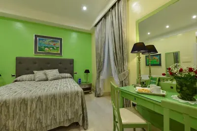a green bedroom with a bed and a desk at Fabio dei Velapazza Guesthouse in Rome