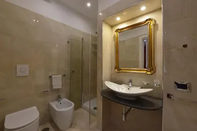 a bathroom with a sink and a toilet and a mirror at Fabio dei Velapazza Guesthouse in Rome