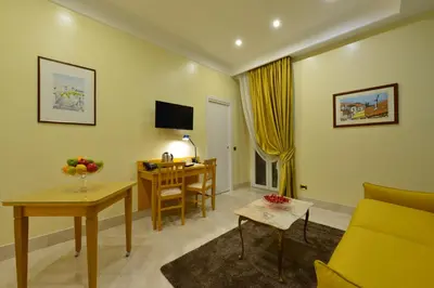 a living room with a yellow couch and a desk at Fabio dei Velapazza Guesthouse in Rome