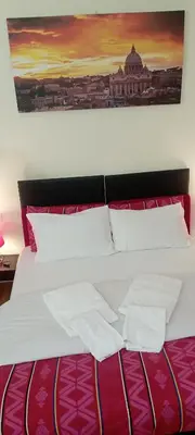 a bed with two pillows and a painting on the wall at Quo Vadis Roma 2 in Rome