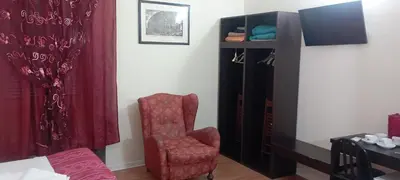 a bedroom with a red chair and a shelf at Quo Vadis Roma 2 in Rome