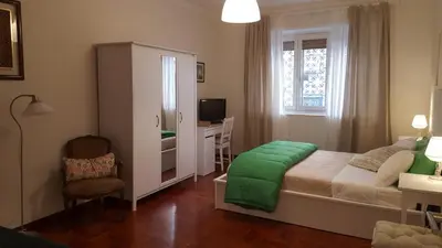 a bedroom with a bed and a desk and a window at homedieci in Rome