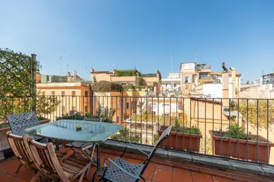 a patio with a table and chairs on a balcony at Trevi Comfortable Apartment with Terrace | Romeloft in Rome