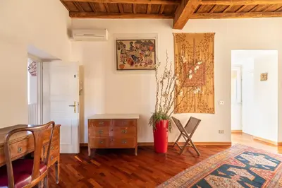 a living room with a table and chairs and a vase at Trevi Comfortable Apartment with Terrace | Romeloft in Rome