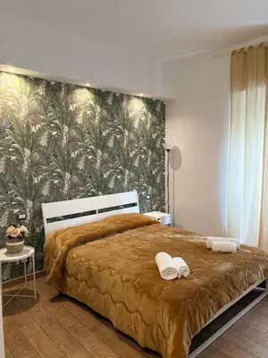 a bedroom with a large bed with a tropical wallpaper at MVM Apartment in Rome