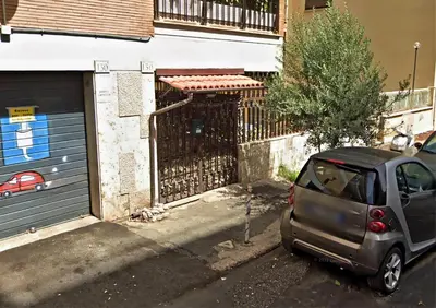 a small car parked in front of a garage at MVM Apartment in Rome
