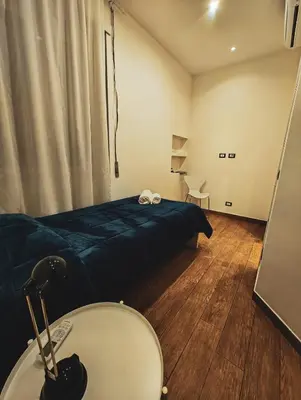 a bedroom with a bed and a table and a mirror at MVM Apartment in Rome