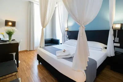 a bedroom with a white bed with a canopy at At Home Townhouse - Filiberto in Rome