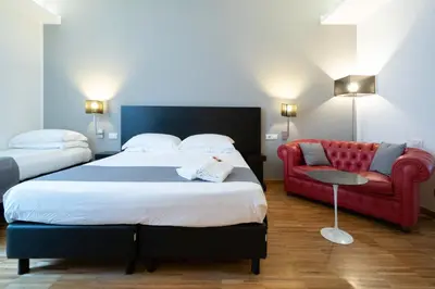 a bedroom with a large bed and a red couch at At Home Townhouse - Filiberto in Rome