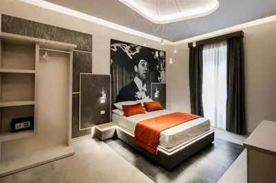 a bedroom with a bed and a painting on the wall at Via Veneto Luxury Suites in Rome