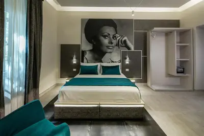 a bedroom with a bed with a painting of a woman at Via Veneto Luxury Suites in Rome