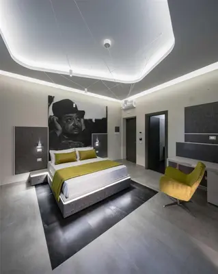 a bedroom with a bed and a painting on the wall at Via Veneto Luxury Suites in Rome