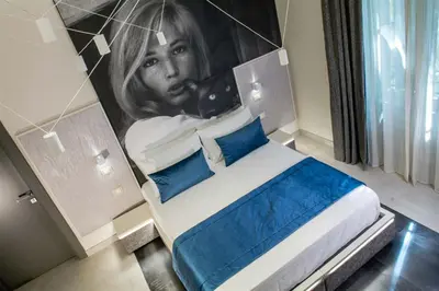 a bedroom with a painting of a woman on the wall at Via Veneto Luxury Suites in Rome