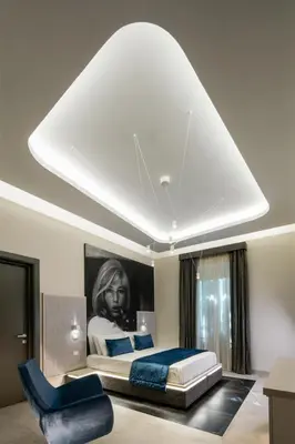 a bedroom with a bed and a painting of a woman at Via Veneto Luxury Suites in Rome