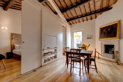 a living room with a table and chairs and a fireplace at Casa Modelli in Rome