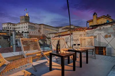 a balcony with chairs and a table with a bottle of wine at Casa Modelli in Rome