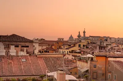 a view of a city at sunset with buildings at Casa Modelli in Rome