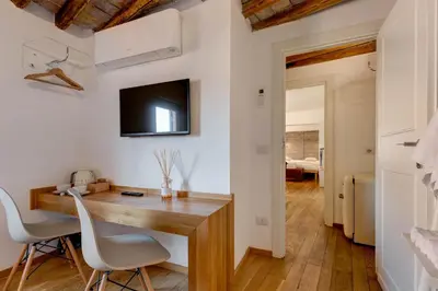 a home office with a wooden desk and a tv on the wall at Casa Modelli in Rome