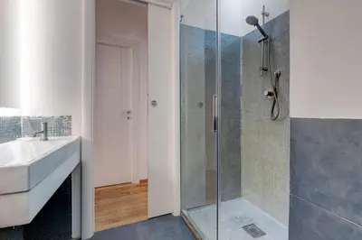 a bathroom with a glass shower and a sink at Casa Modelli in Rome