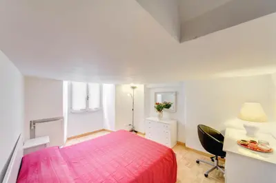 a white bedroom with a pink bed and a desk at Campo dei Fiori Stunning and Quiet in Rome