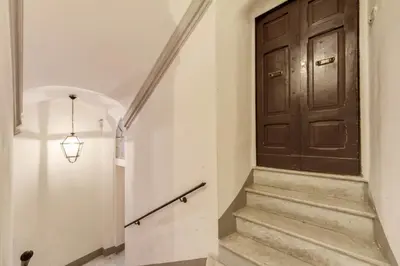 a hallway with a wooden door and stairs at Campo dei Fiori Stunning and Quiet in Rome