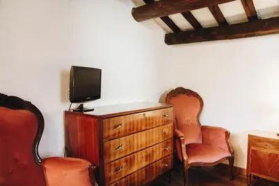 a room with a tv and two chairs and a dresser at Suite Rondanini in Rome