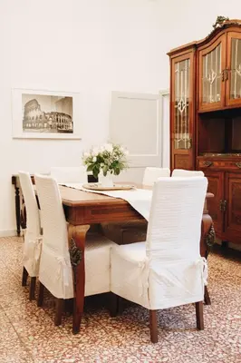 a dining room with a wooden table and white chairs at Suite Rondanini in Rome