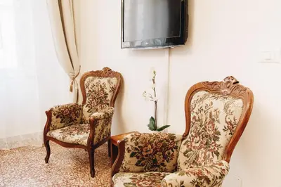 two chairs and a tv in a room at Suite Rondanini in Rome