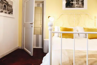 a bedroom with a white bed and a bathroom at Suite Rondanini in Rome