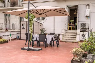 a table and chairs under an umbrella on a patio at Circus Maximus Home in Rome