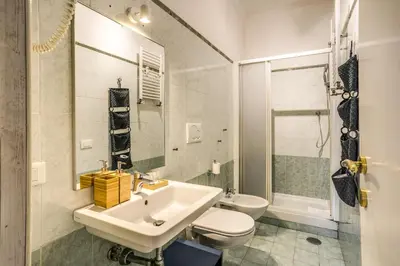 a white bathroom with a sink and a toilet at Circus Maximus Home in Rome