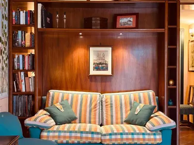 a couch in a living room with bookshelves at Paradiso Borgia in Rome