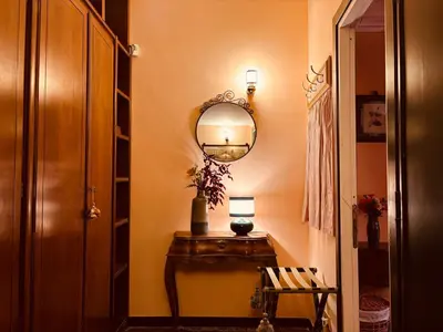 a hallway with a table with a mirror and a chair at Paradiso Borgia in Rome