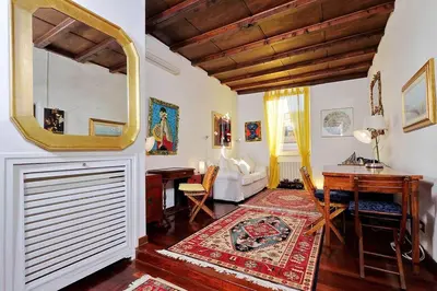 a living room with a table and a mirror at Trastevere Lovely Studio Apartment in Rome