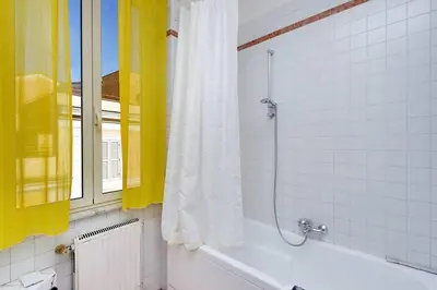 a bathroom with a tub and a window and a shower at Trastevere Lovely Studio Apartment in Rome