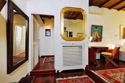 a hallway of a home with a mirror and a table at Trastevere Lovely Studio Apartment in Rome