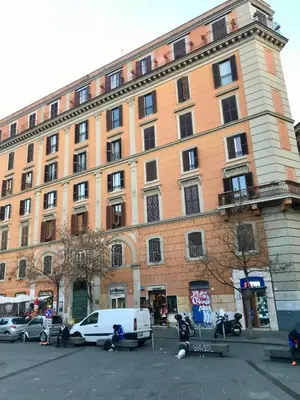 a large building with cars parked in front of it at san cosimato suite in Rome