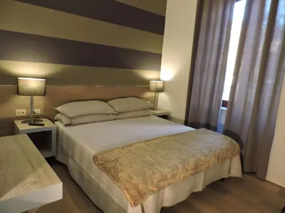 a bedroom with a large bed and two lamps at san cosimato suite in Rome