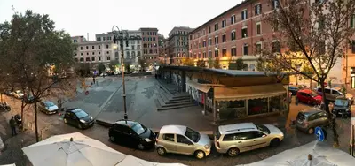 a city with cars parked in a parking lot at san cosimato suite in Rome