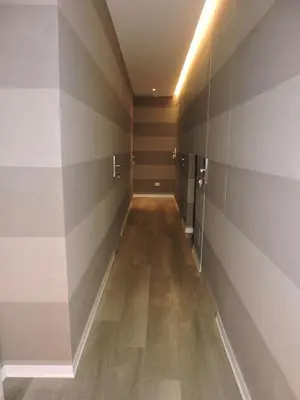 a hallway with striped walls and a wooden floor at san cosimato suite in Rome