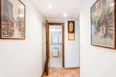 a hallway with framed paintings on the walls and a doorway at FL Apartments Al Mattonato n4 in Rome